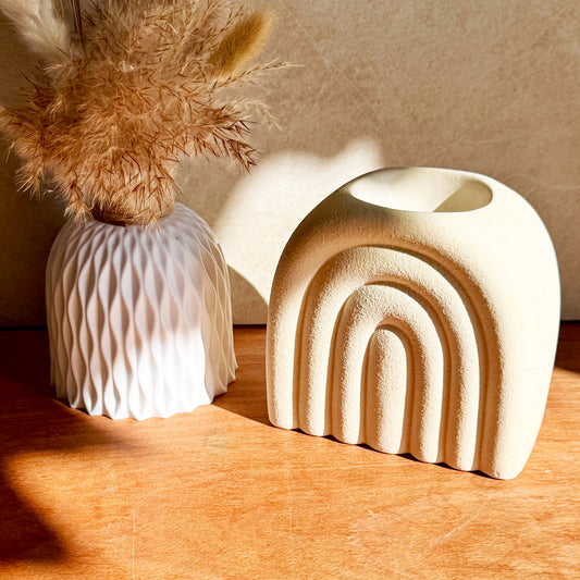 Cream Speckle Arch Wax Melt Burner with Textured Dolomite Finish, Displayed on Wooden Surface with White Ceramic Vase and Pampas Grass in Natural Sunlight