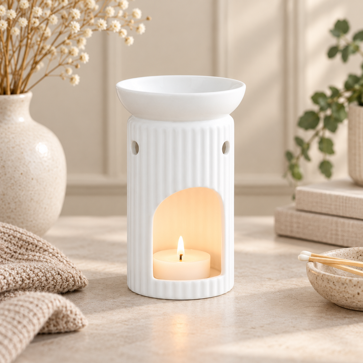 White Ribbed Wax Melt Burner with a lit candle, creating a warm atmosphere in a cozy home setting.