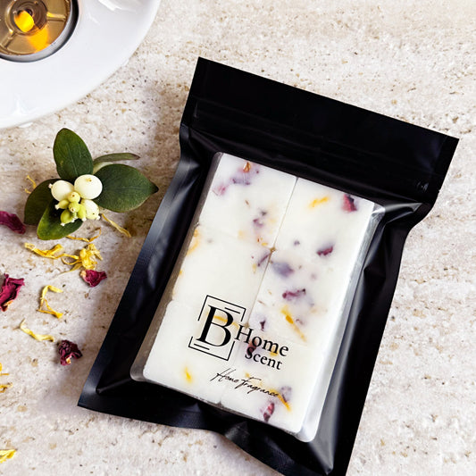 Caramel Vanilla Latte scented wax melts - Pack of six wax melts in a black resealable pouch with visible flower petals, placed near a white wax melt burner and loose dried petals.