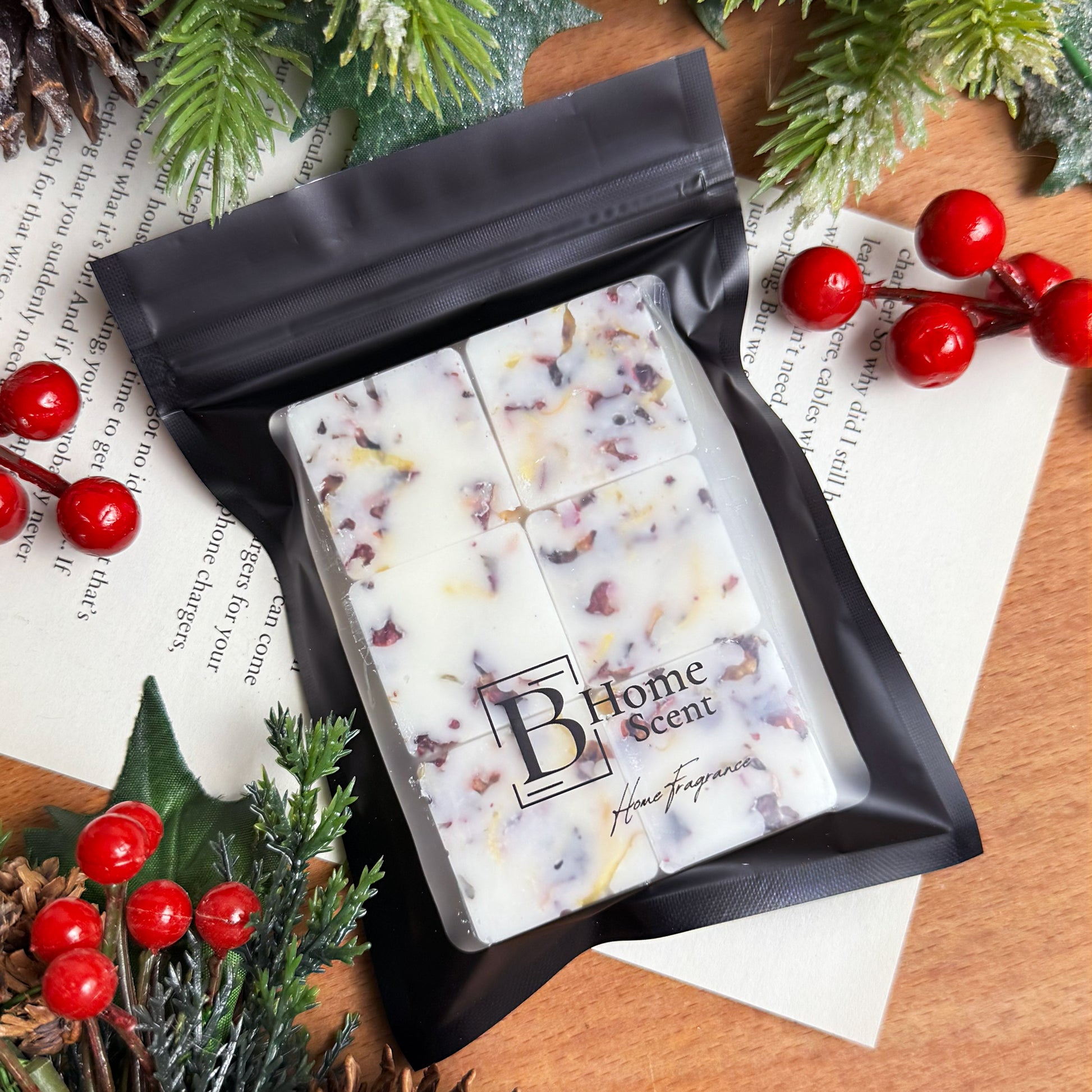 Handcrafted Gingerbread wax melt  in black zip bag packaging, surrounded by festive greenery and berries.