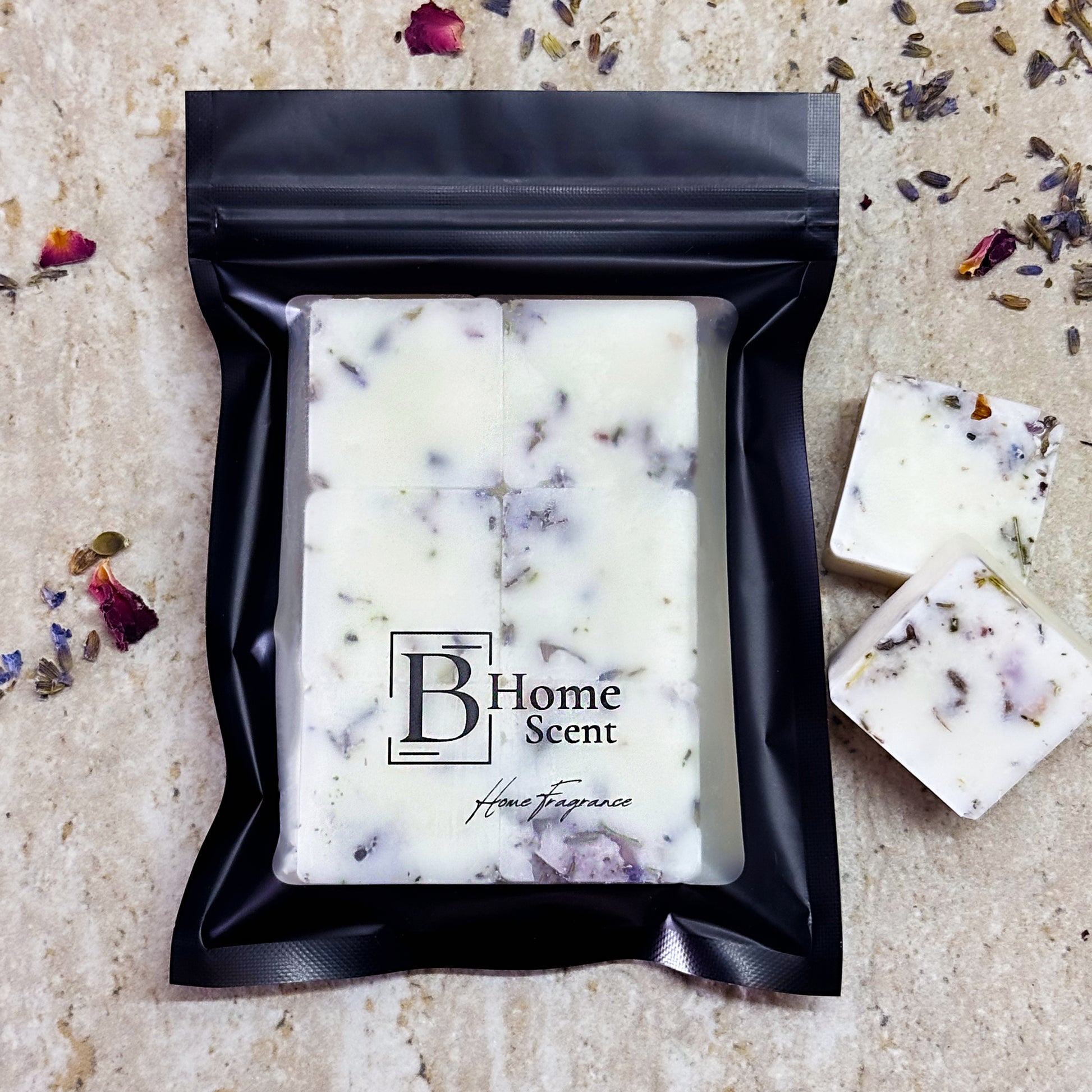 A bag of Blueberry & Jasmin wax melts infused with dried lavender and rose petals. The wax melts are displayed on a light surface, with some loose wax cubes outside the bag. The packaging features the "BHome Scent" label, highlighting the product as a home fragrance.