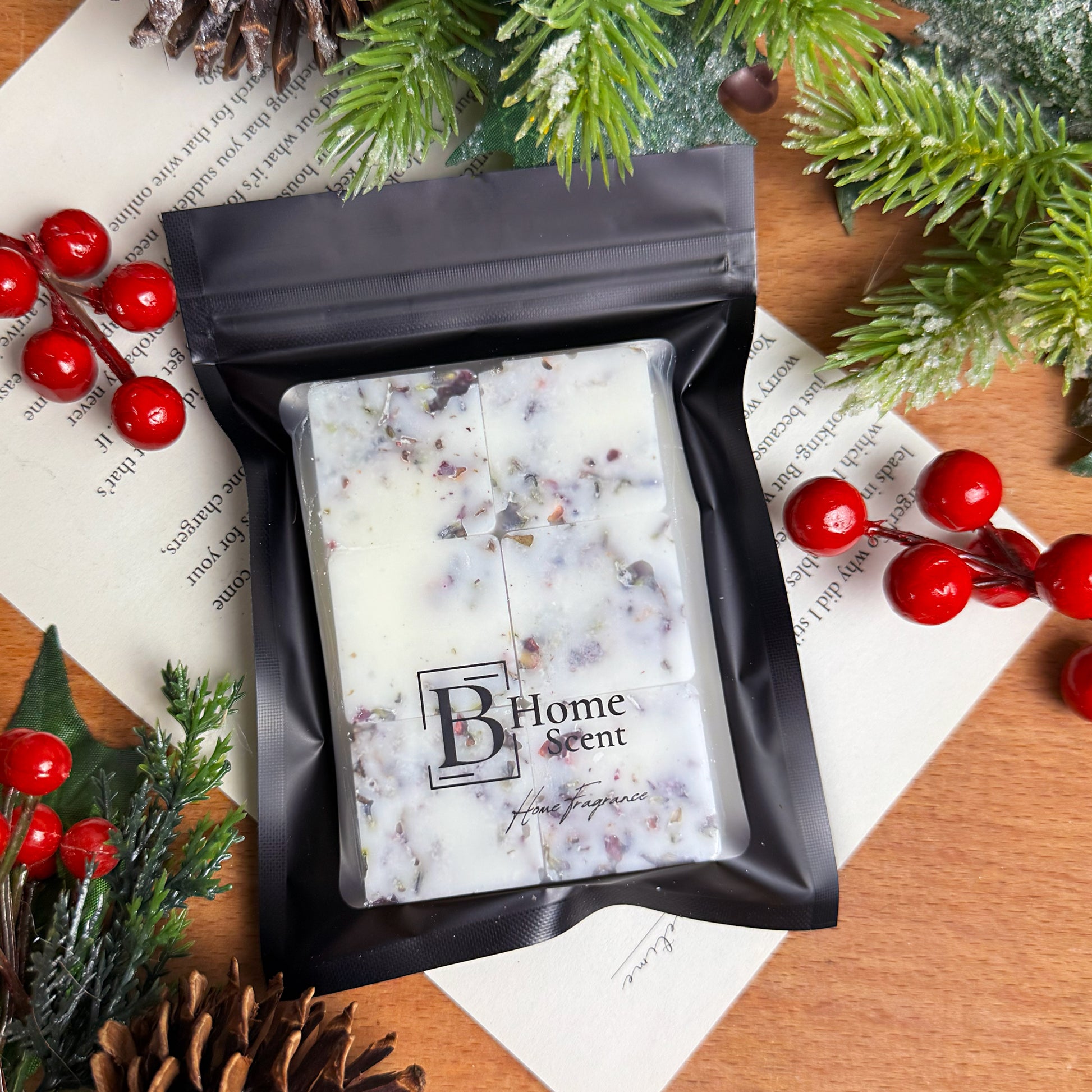 Handcrafted Nutcracker wax melt snap bar in black zip bag packaging, surrounded by festive greenery and berries.