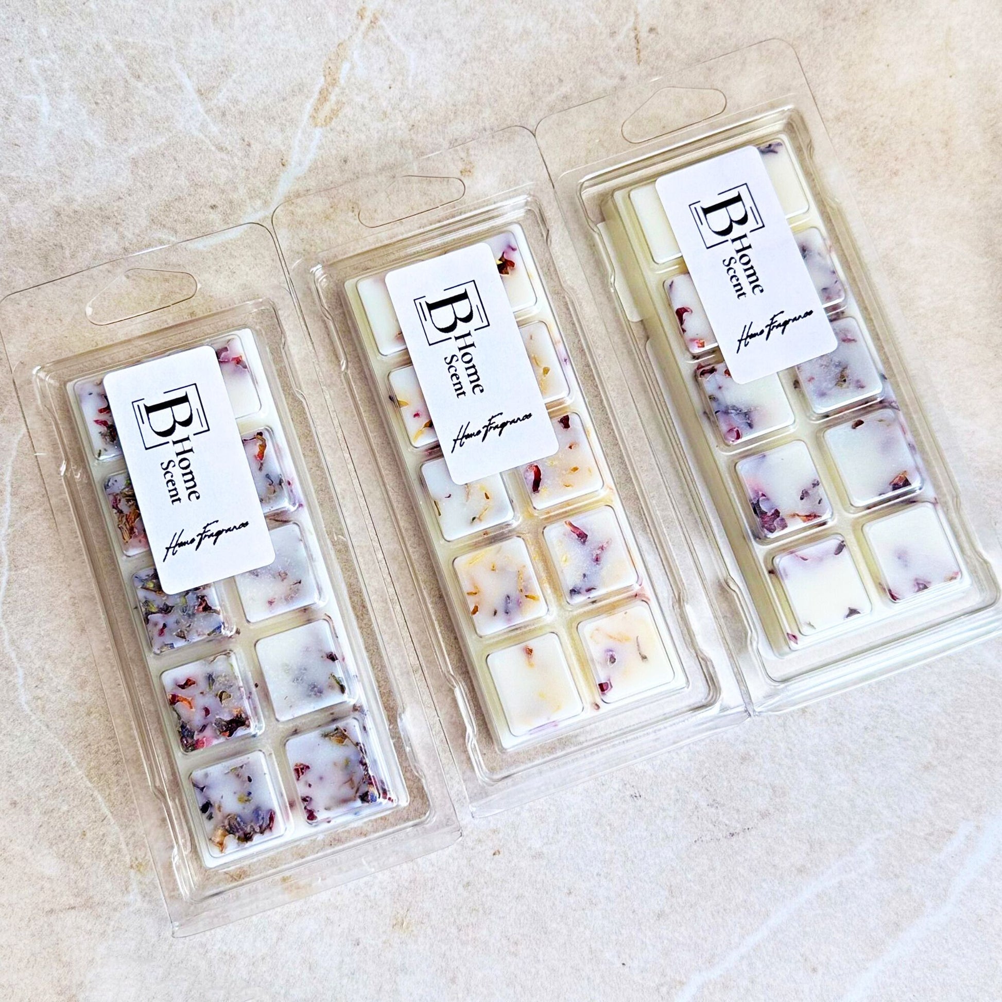 Three botanical wax melt snap bars from the BHOMESCENT Autumn Collection displayed on a light marble surface