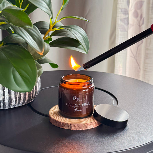 Lighting amber candle UK with golden pear fragrance, home decor setup