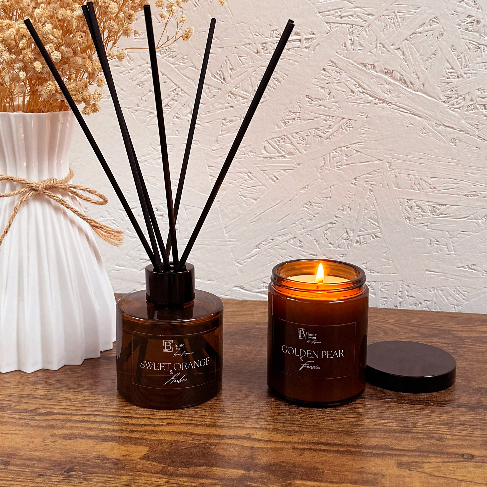 candle burning next to Sweet Orange and Amber reed diffuser creating a cosy home atmosphere