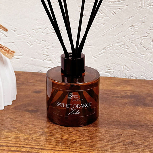 sweet orange and amber reed diffuser on the wooden table.